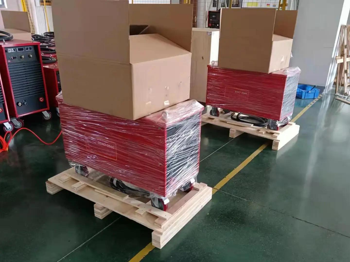 Stud welding machines wrapped in protective film and arranged on pallets for shipment.