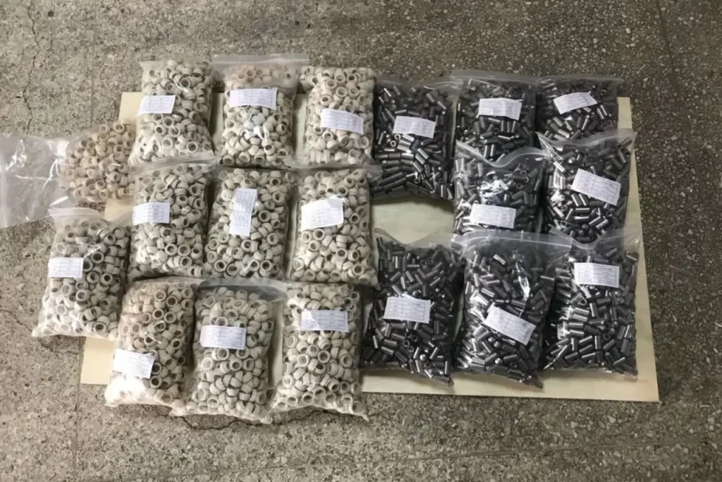 Sealed bags of industrial ceramic ferrules and steel welding studs ready for international shipping.