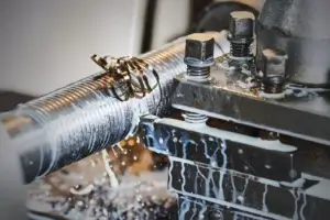 CNC lathe machine precision threading and turning operation on steel weld studs.