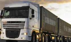 A heavy-duty logistics truck carrying shipping containers on a highway, representing ZOC Machinery's road freight and local delivery capabilities.