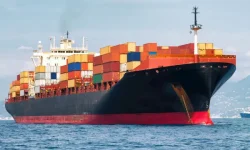 A large container ship loaded with colorful cargo containers sailing on the ocean, representing ZOC Machinery's primary international shipping method.