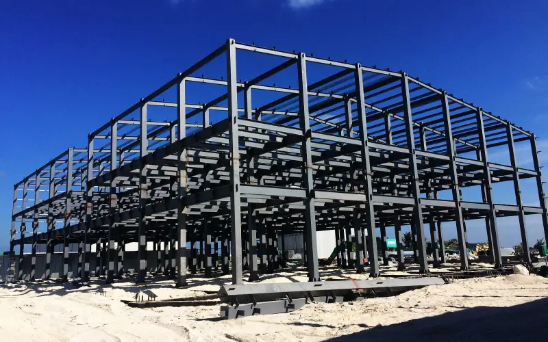 A multi-story steel frame building under construction, showcasing the structural framework where shear studs are used for composite floor systems.
