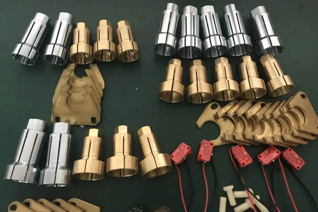 A collection of silver steel and golden brass stud welding chucks, ferrule pressing plates, and red industrial micro switches.
