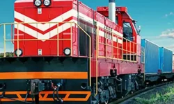 A heavy-duty freight locomotive pulling cargo containers on a railway, illustrating ZOC Machinery's rail transport options for international shipping.